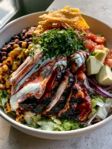 Close up of mahogany glazed chicken slices with grill marks on a BBQ Chicken Chopped Salad. (BBQ Chicken Chopped Salad)