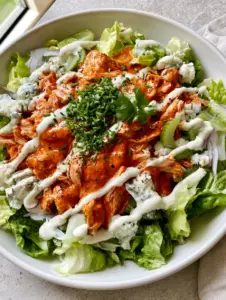 Top-down view of a vibrant Buffalo Chicken Salad in a white ceramic bowl. (Buffalo Chicken Salad)