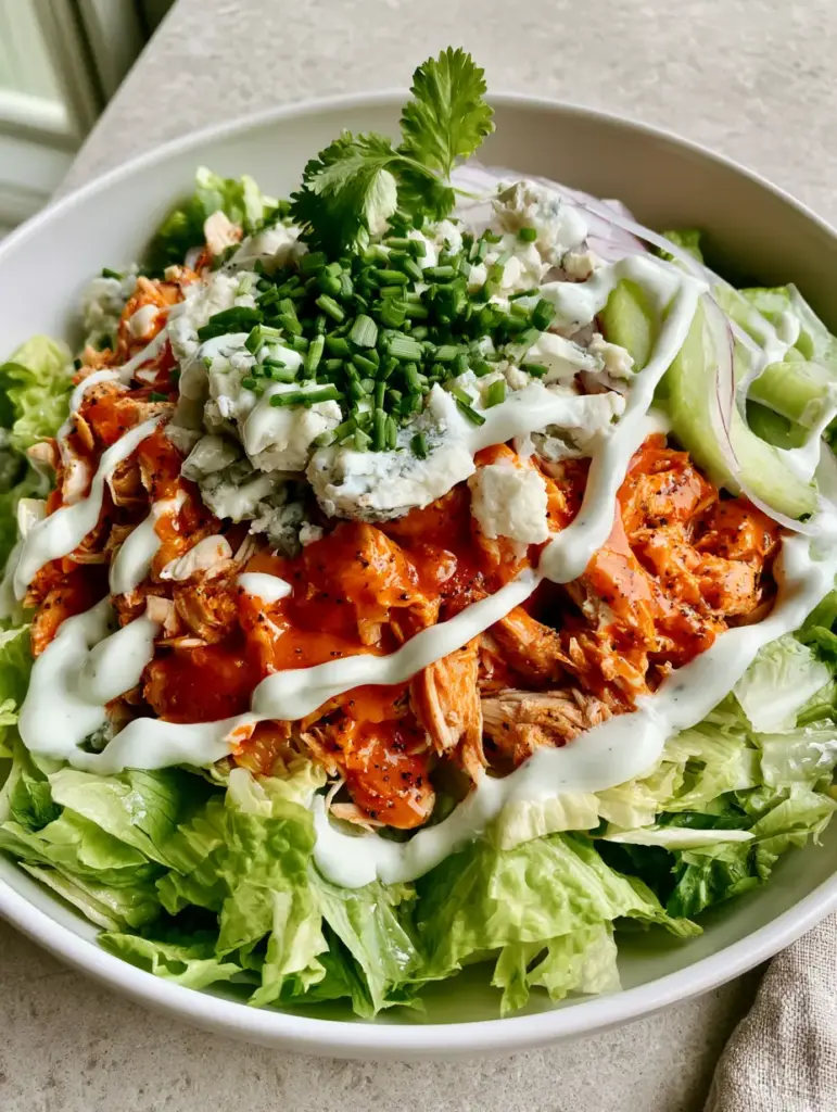 Close-up of creamy ranch drizzle and blue cheese on a Buffalo Chicken Salad.